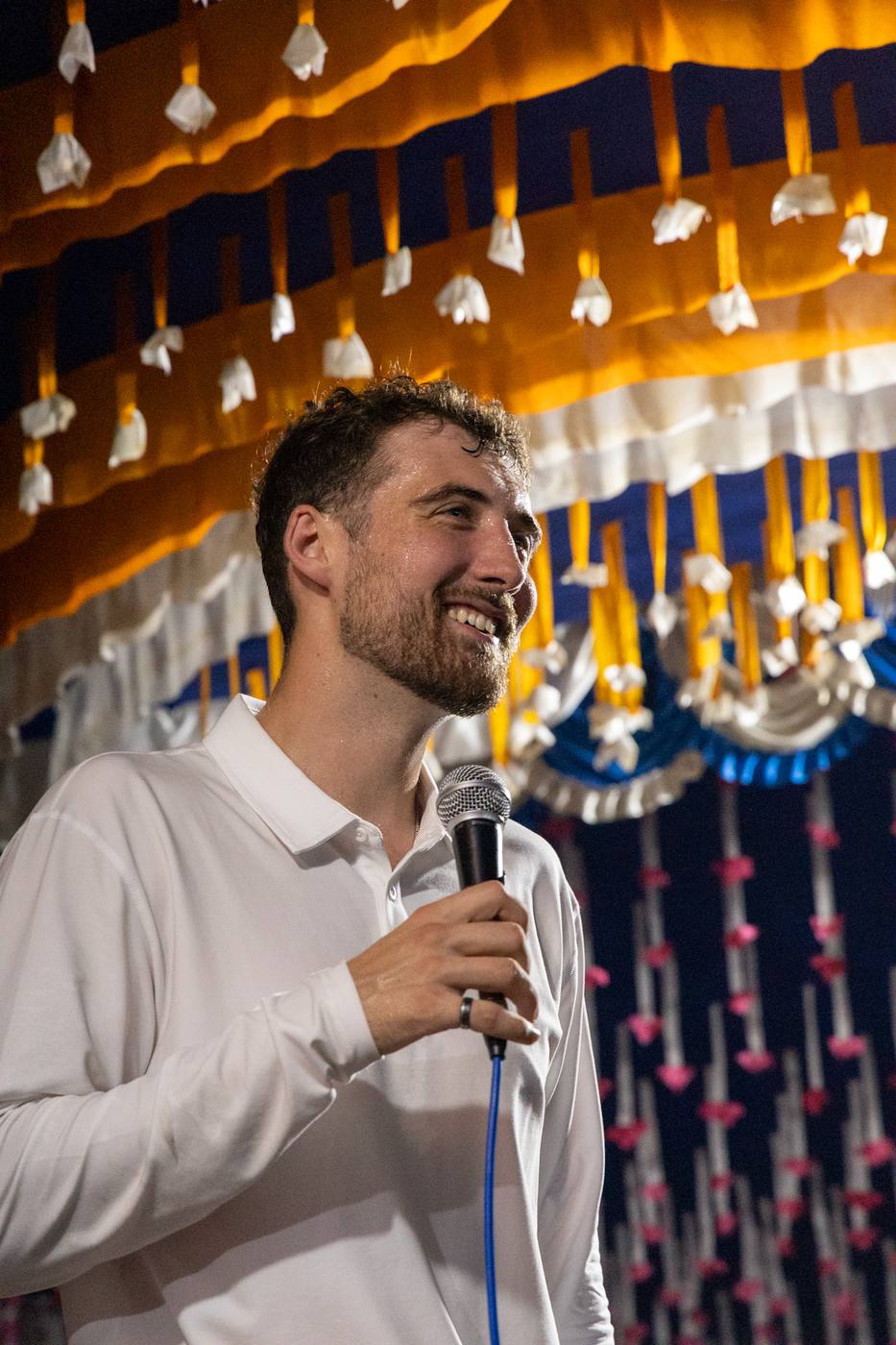 Chris smiling with a microphone at a crusade in Bangladesh